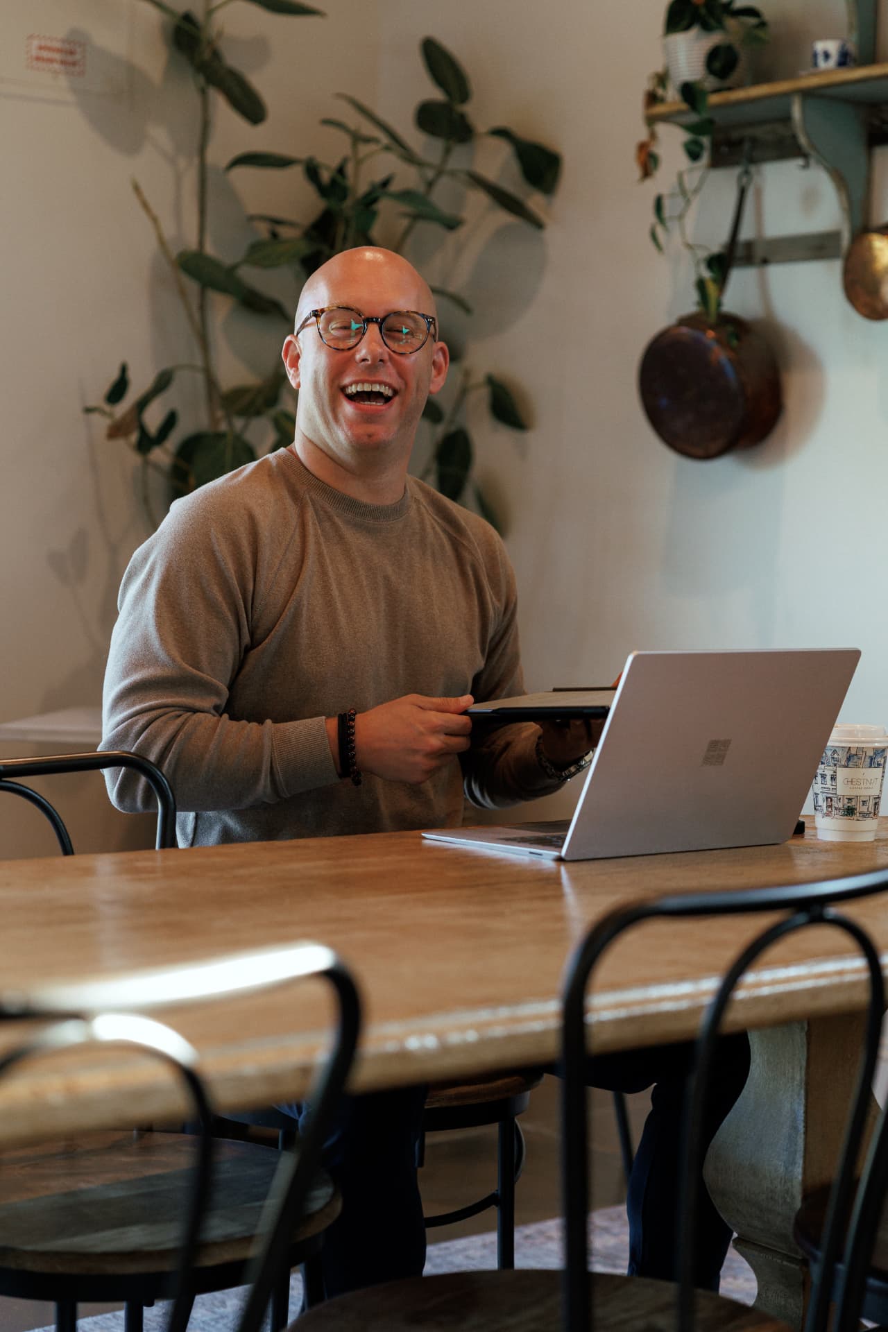 Zach Barnett laughing at a table with his laptop